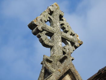 Low angle view of old cross against sky