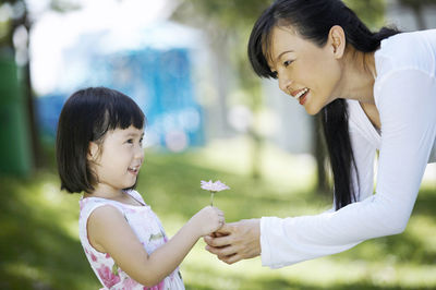 Happy mother and daughter against trees