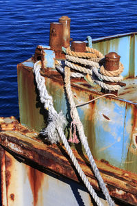 Close-up of rope tied on rusty cleat