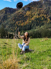 Full length of young woman sitting on field