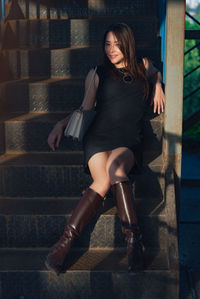 Portrait of young woman sitting on steps