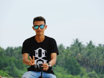 Portrait of young man against sky