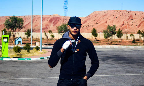 Young man wearing sunglasses standing on road