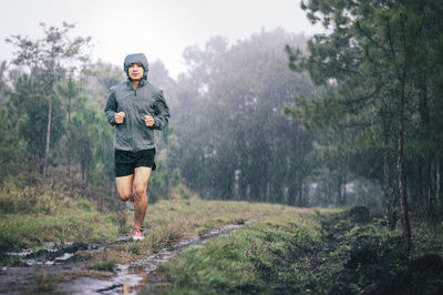 Young man jogging on footpath during monsoon