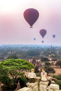 Hot air balloons flying over landscape