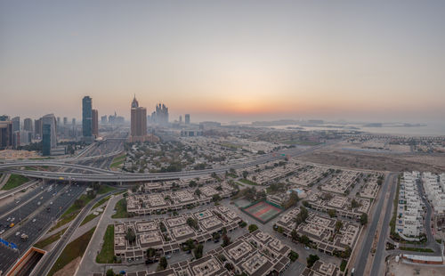 Aerial view of buildings in city during sunset