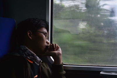 A man looking through train window