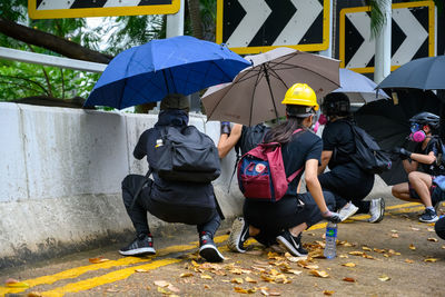 Rear view of people with umbrella on rainy day