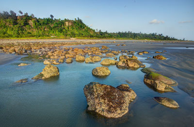 Scenic view of rocks in sea against sky