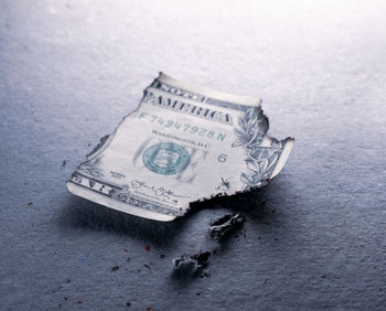 Close-up of burnt paper currency on table