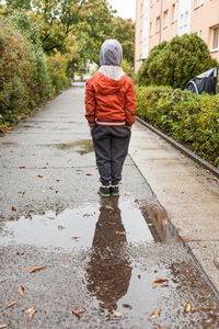 Rear view of woman walking on road