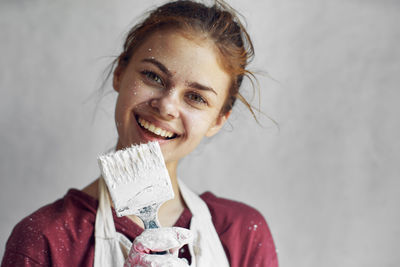 Portrait of young woman holding paintbrush