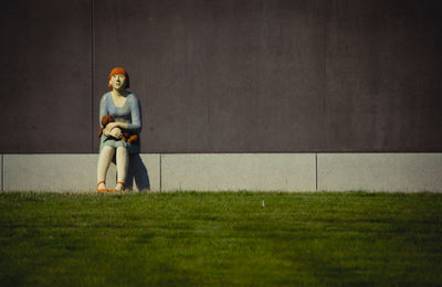 Portrait of young man sitting on concrete wall