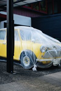 Close-up of yellow car on street