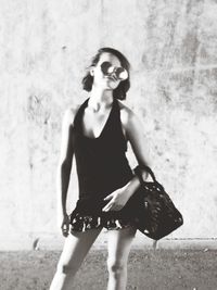 Portrait of woman standing against wall