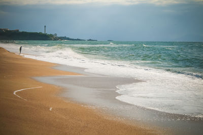 Scenic view of beach and lighthouse against sky in basque country