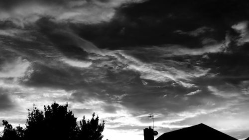 Low angle view of silhouette tree against cloudy sky