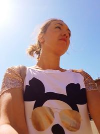 Low angle view of woman looking against sky