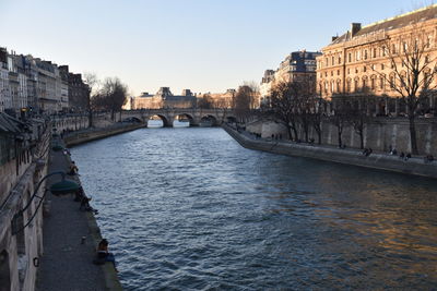 Bridge over river against buildings in city