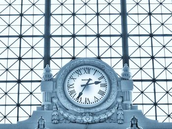 Low angle view of clock on ceiling of building