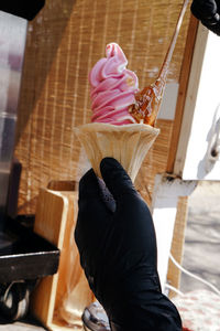 Pink yogurt ice cream cone from the beach route and staff pouring honey ice cream in hand.