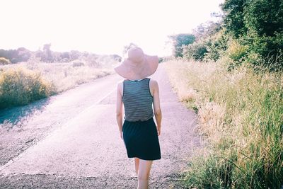 Rear view of woman walking on road