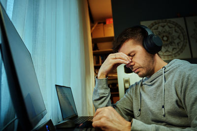 Side view of young man working at home