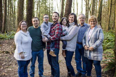 Portrait of happy family in forest setting.