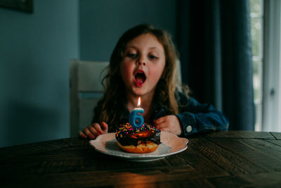 Portrait of boy with ice cream in plate on table