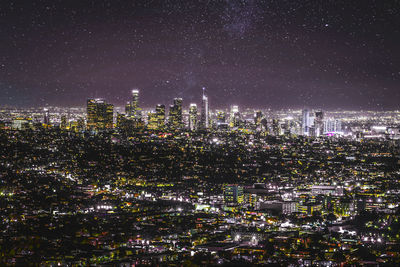 Illuminated cityscape against sky at night