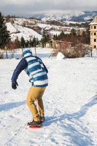 Man learning to snowboard during winter