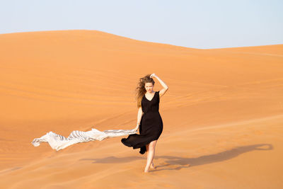 Side view of woman standing in desert