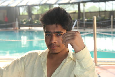 Portrait of young man against swimming pool