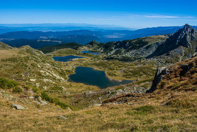 Scenic view of landscape and mountains against blue sky