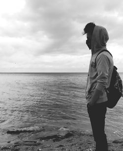 Man looking at sea shore against sky