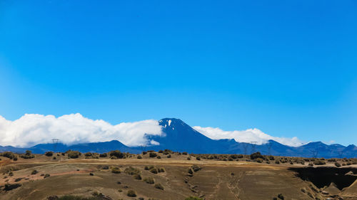 Scenic view of desert against blue sky