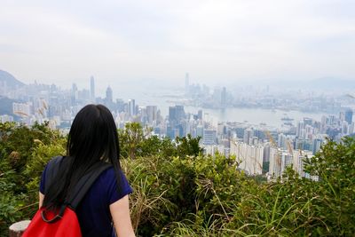 Rear view of woman with cityscape in background