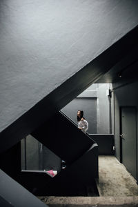 Young man standing on staircase in building