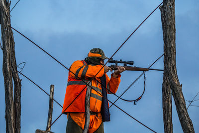 Low angle view of men working against sky