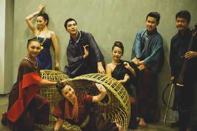 Models wearing traditional clothing while posing against wall