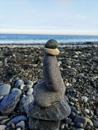 Close-up of pebbles on beach against sky