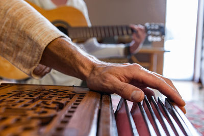 Close-up of man playing guitar on table