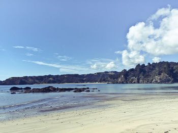 Scenic view of sandy beach against blue sky