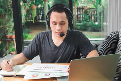 Mid adult man using mobile phone while sitting on table