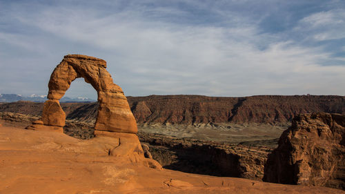 Rock formations on landscape against cloudy sky