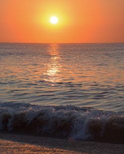 Scenic view of sea against orange sky