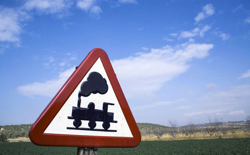 Information sign on field against sky