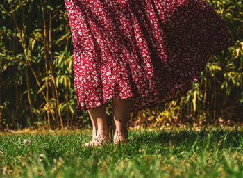 Low section of woman standing on grass