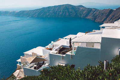 Buildings by sea against sky