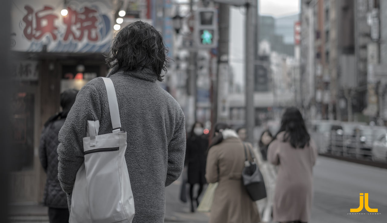 REAR VIEW OF PEOPLE WALKING ON STREET